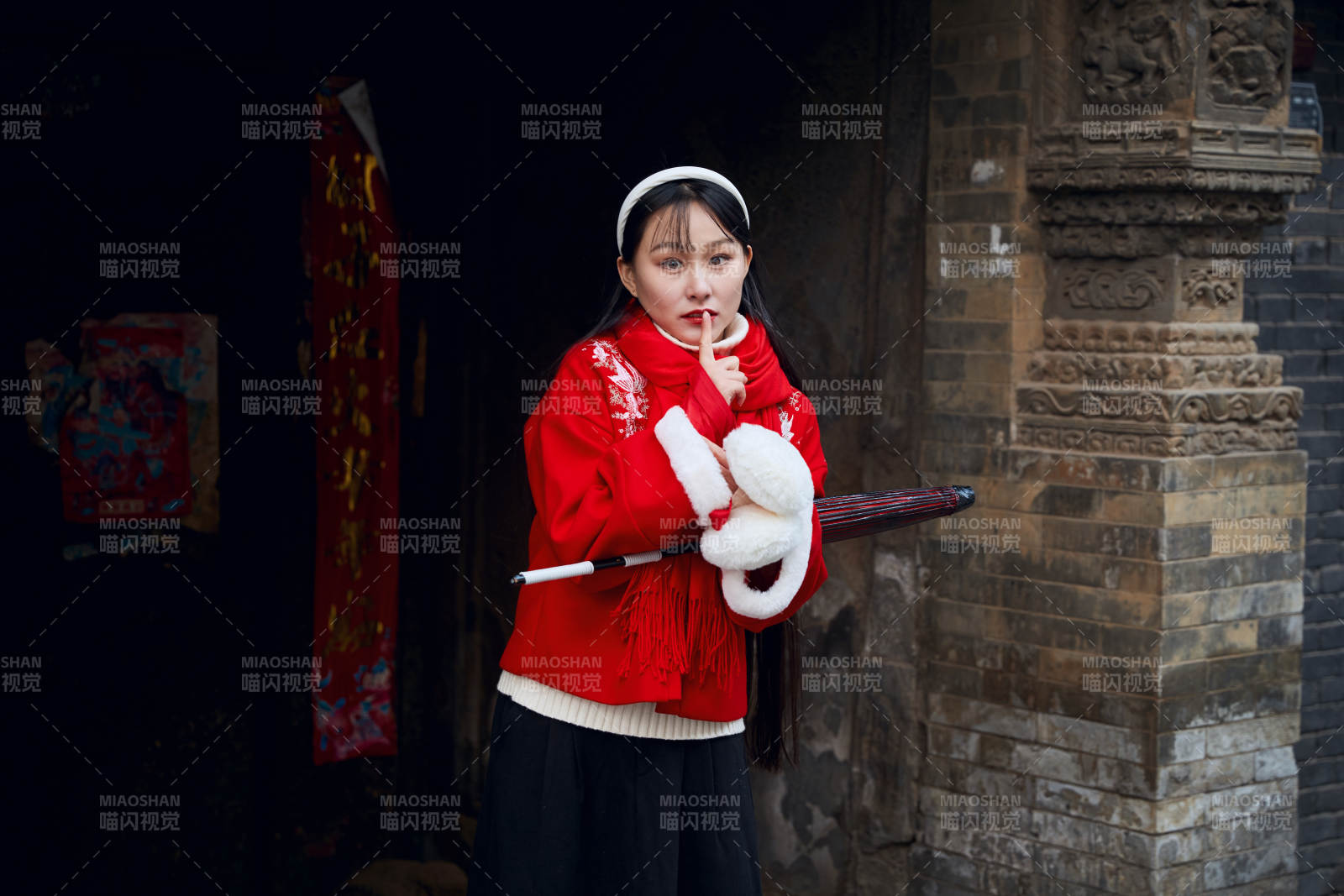 雪后在老城古巷穿着喜庆服饰的亚洲少女图片