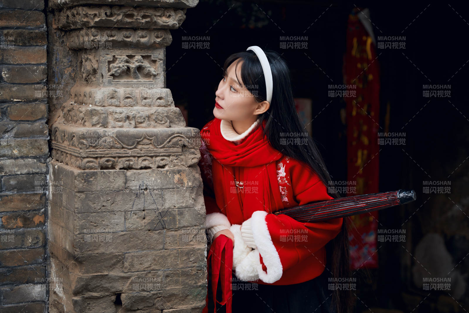 雪后在老城古巷穿着喜庆服饰的亚洲少女图片