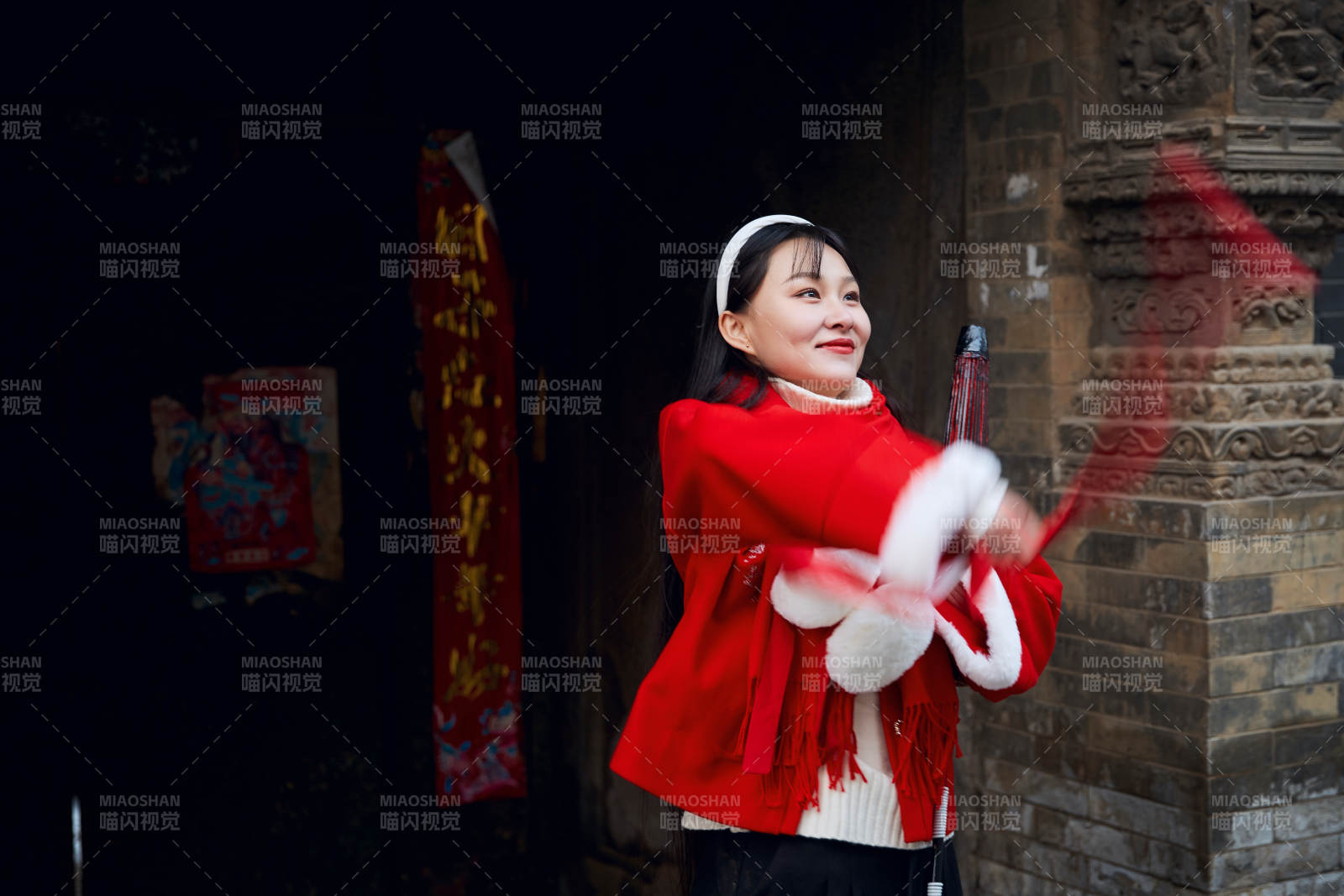 雪后在老城古巷穿着喜庆服饰的亚洲少女图片