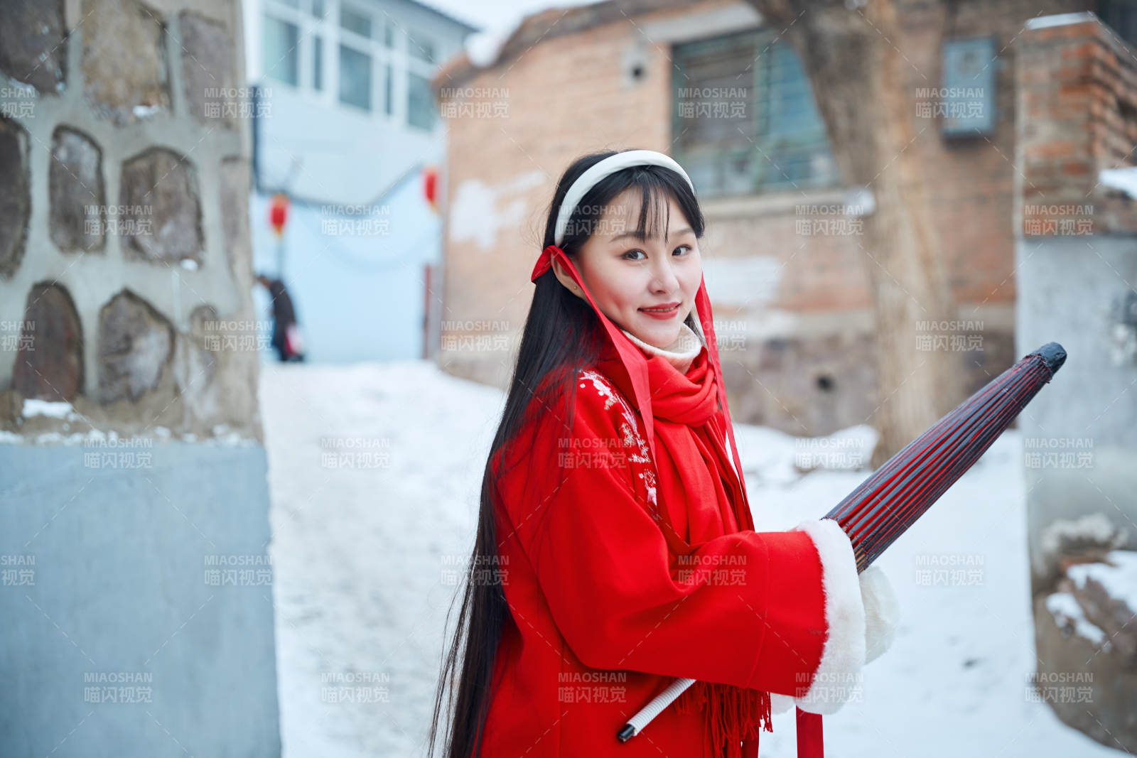 雪后在老城古巷穿着喜庆服饰的亚洲少女图片