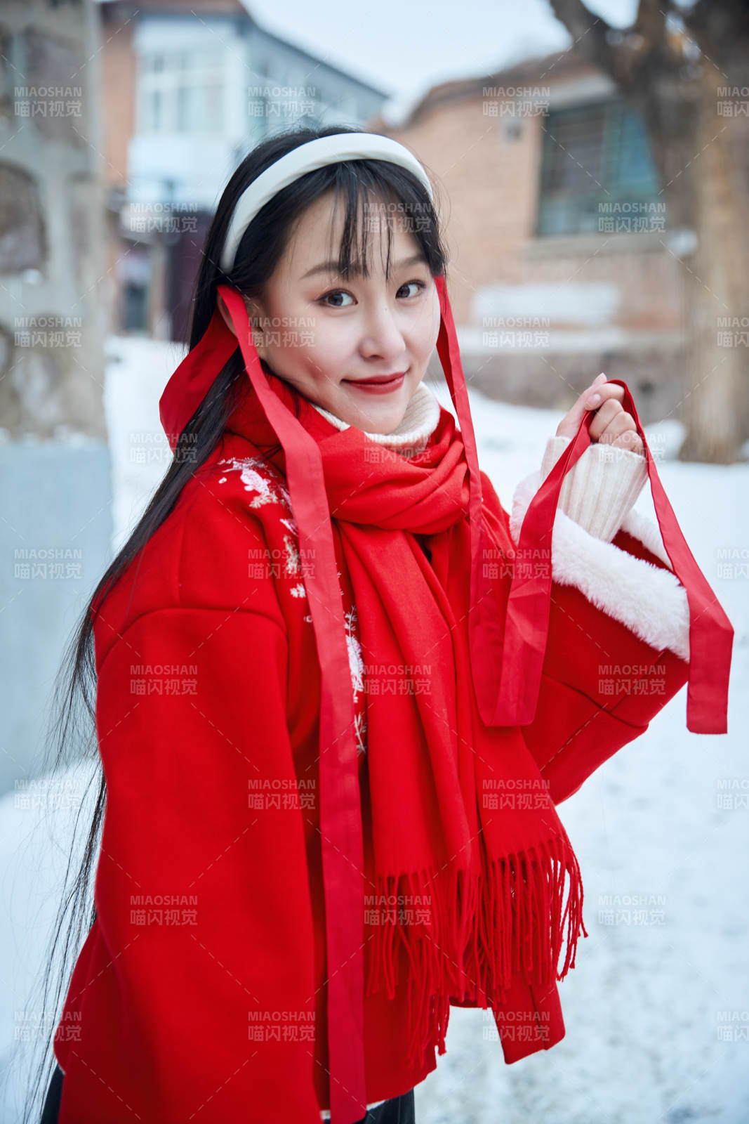 雪后在老城古巷穿着喜庆服饰的亚洲少女图片