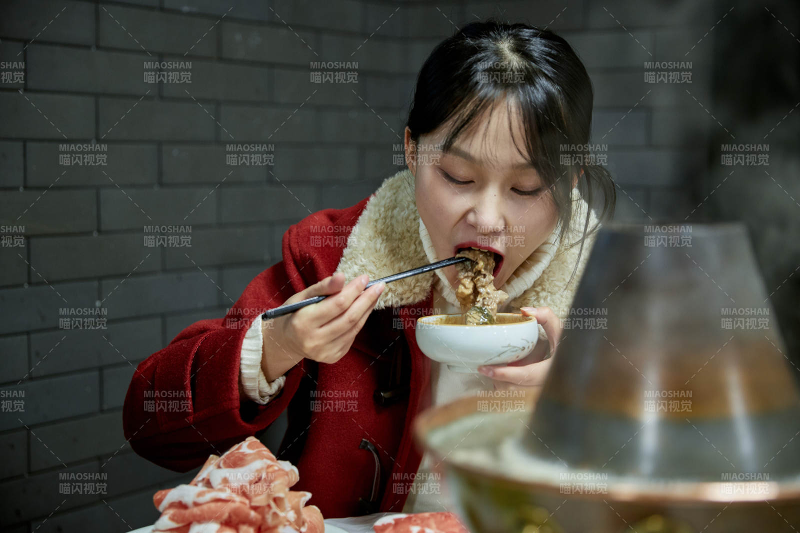 在饭店吃传统铜锅涮肉的亚洲少女图片