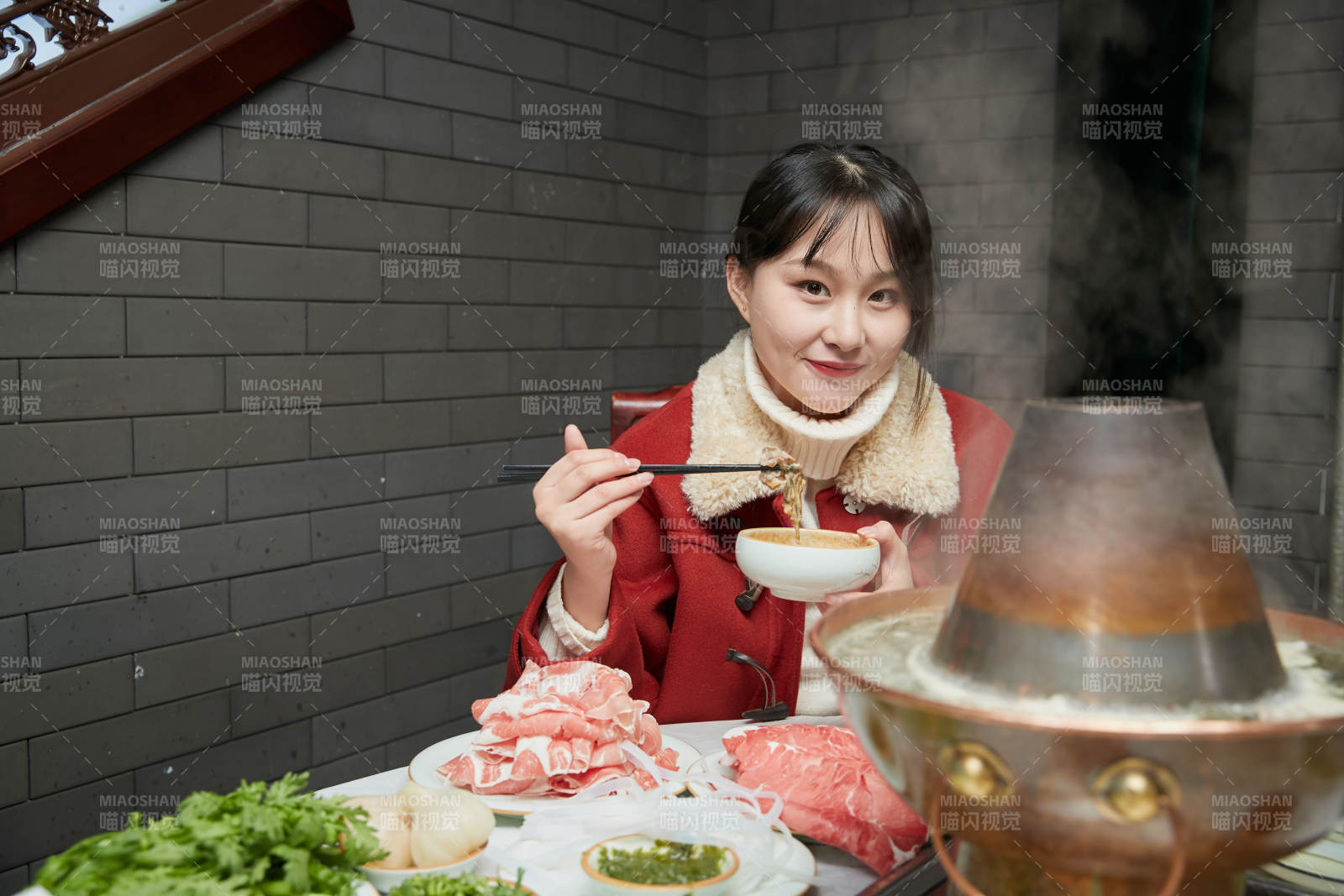 在饭店吃传统铜锅涮肉的亚洲少女图片