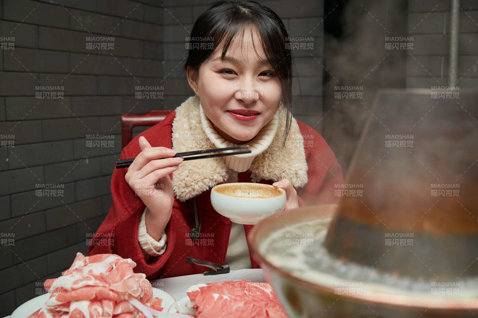 在饭店吃传统铜锅涮肉的亚洲少女图片