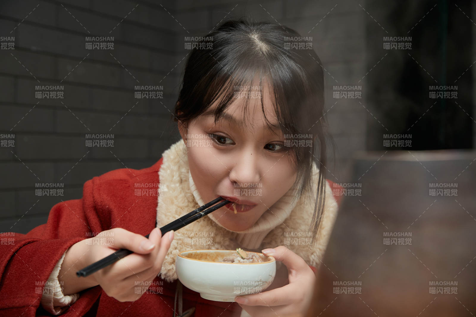 在饭店吃传统铜锅涮肉的亚洲少女图片