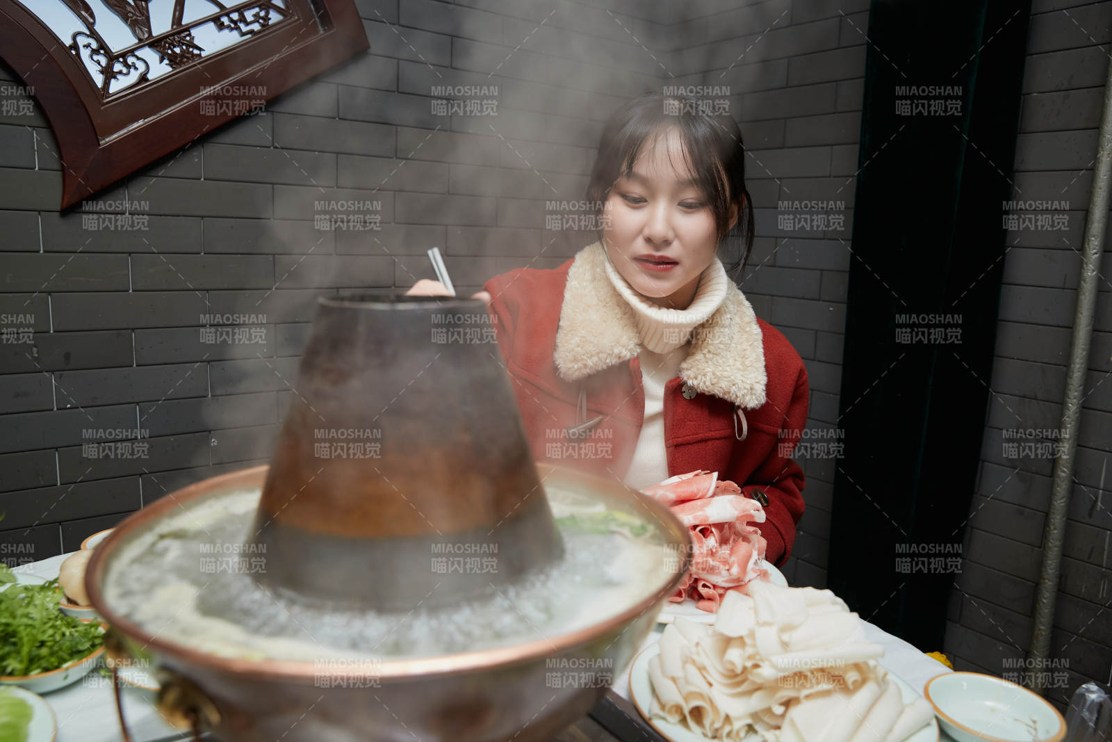 在饭店吃传统铜锅涮肉的亚洲少女图片