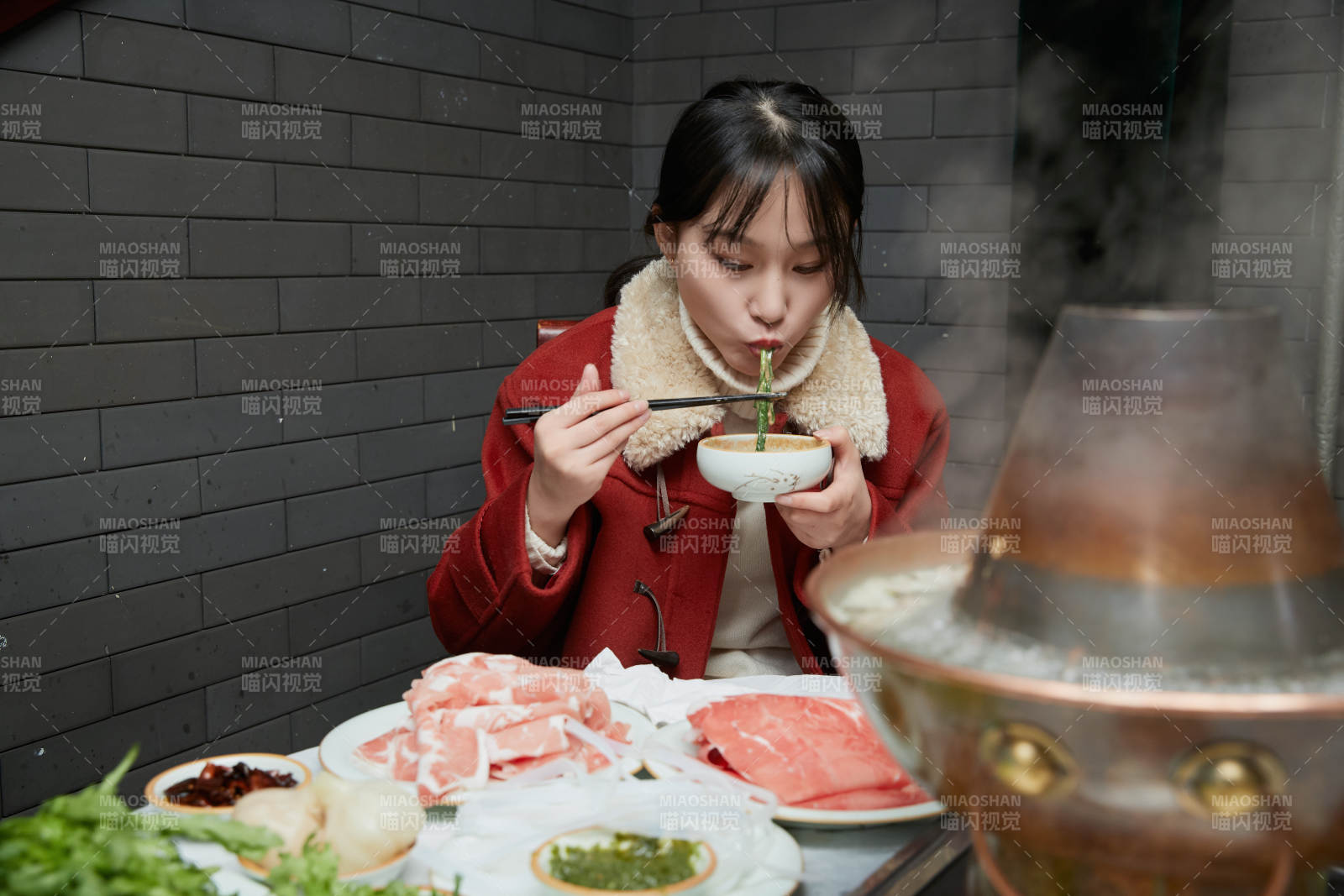 在饭店吃传统铜锅涮肉的亚洲少女图片