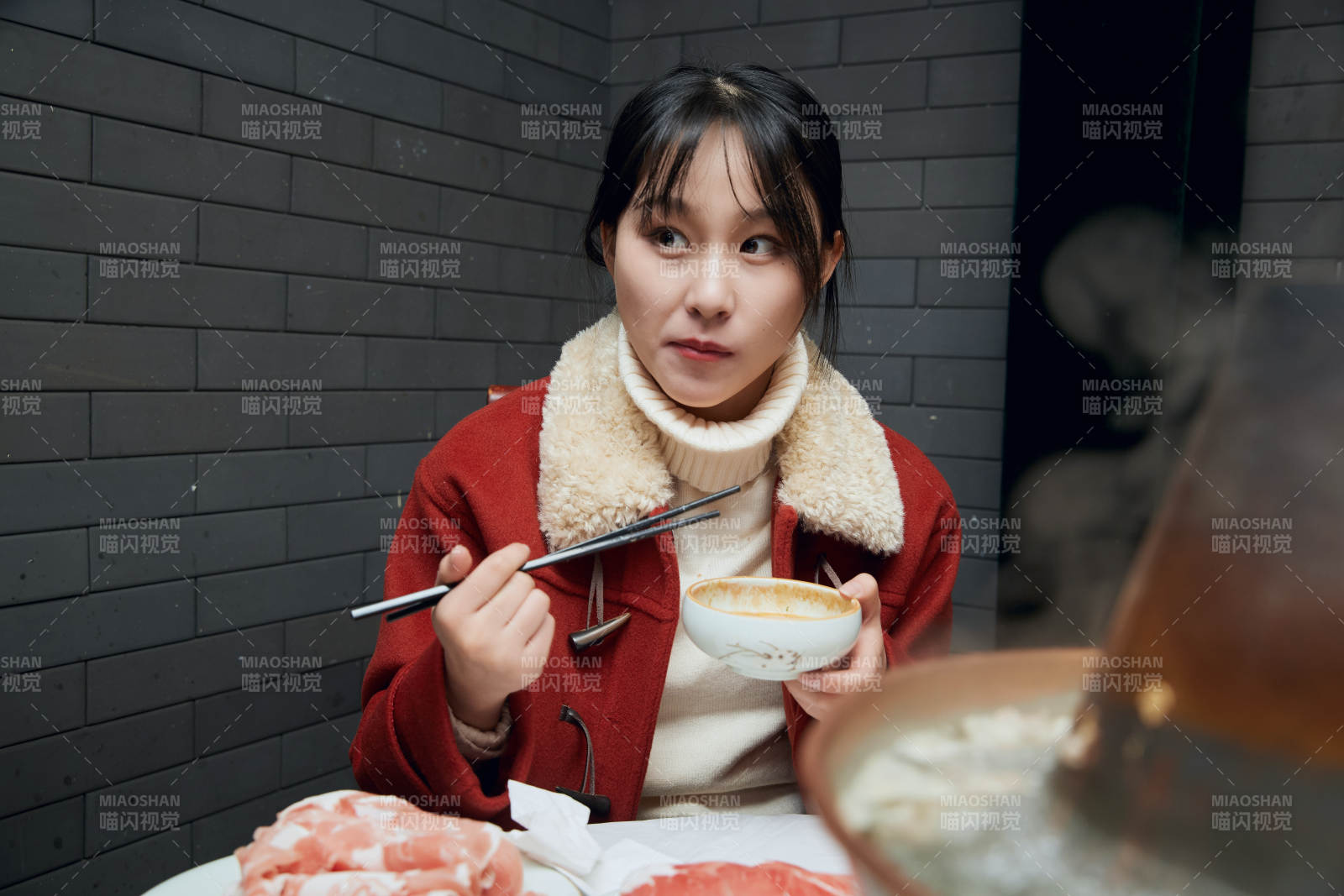 在饭店吃传统铜锅涮肉的亚洲少女图片