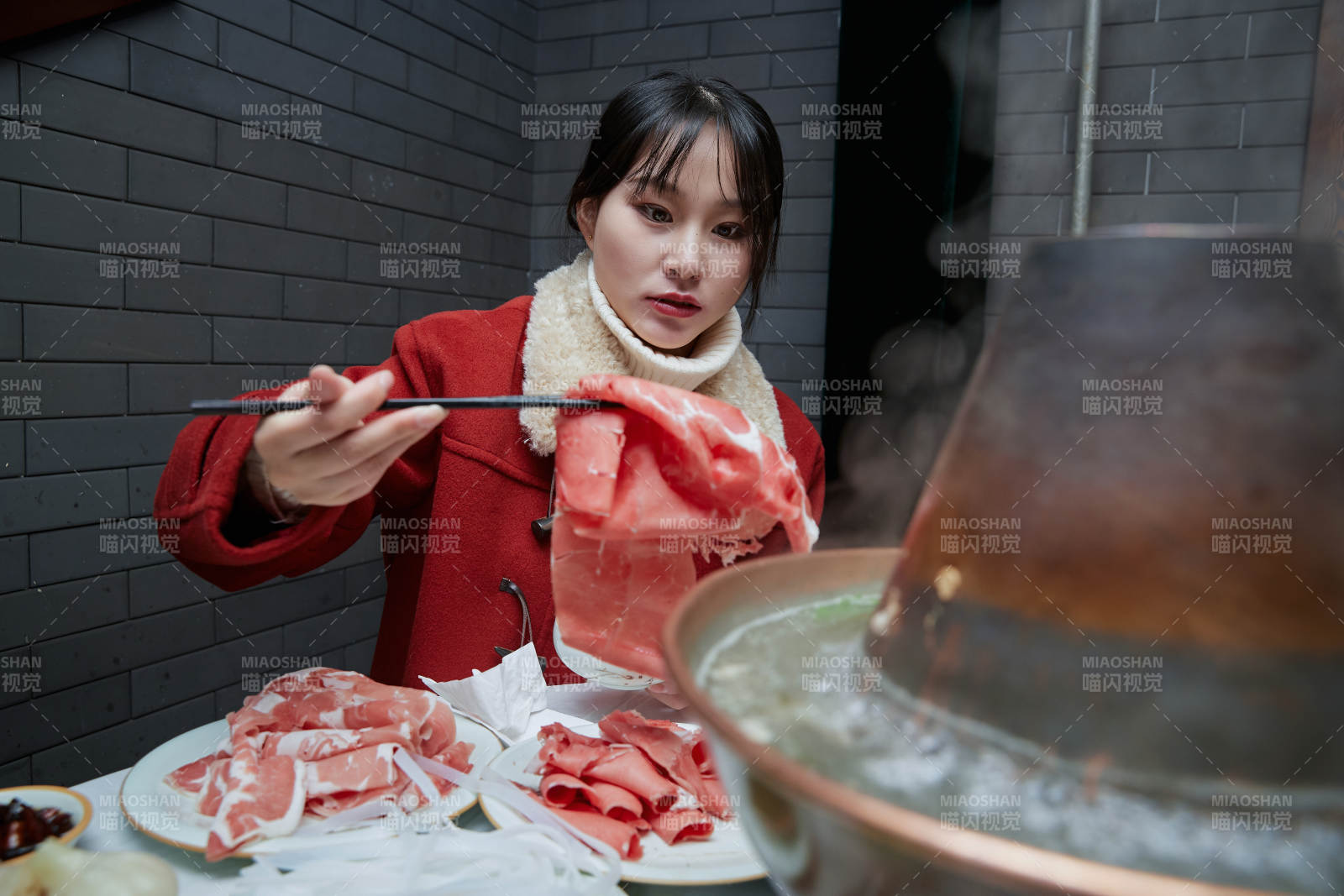 在饭店吃传统铜锅涮肉的亚洲少女图片