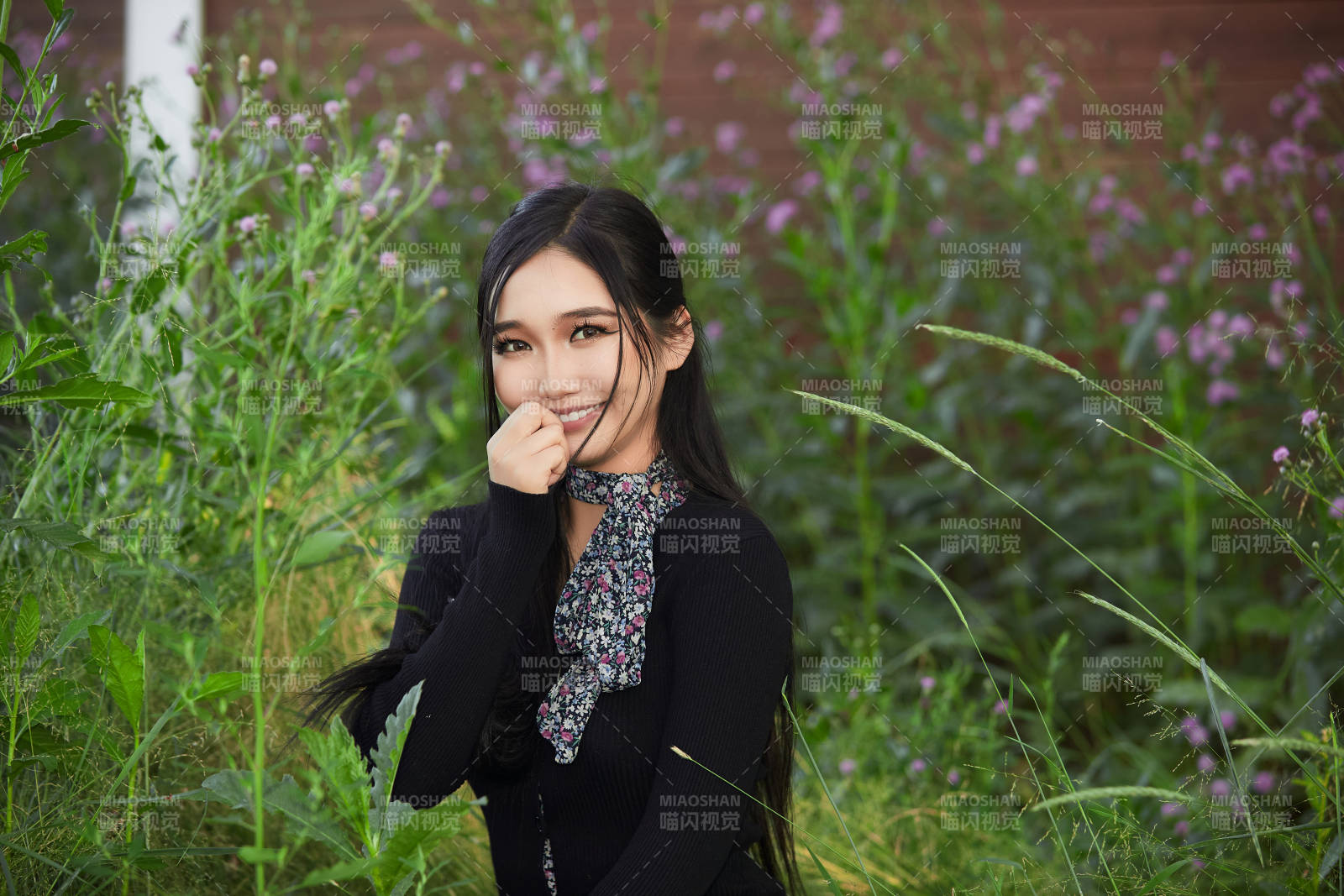 盛夏夕阳照射下花丛草地中的亚洲美女图片