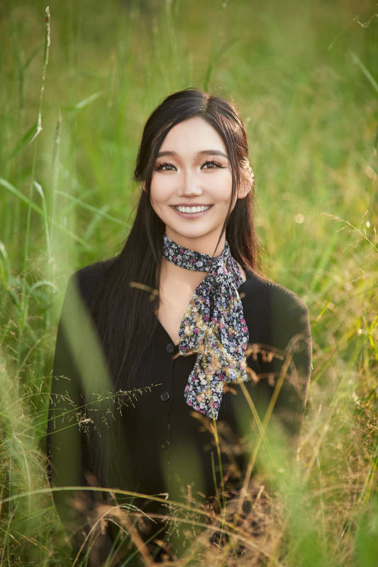 盛夏夕阳照射下花丛草地中的亚洲美女图片