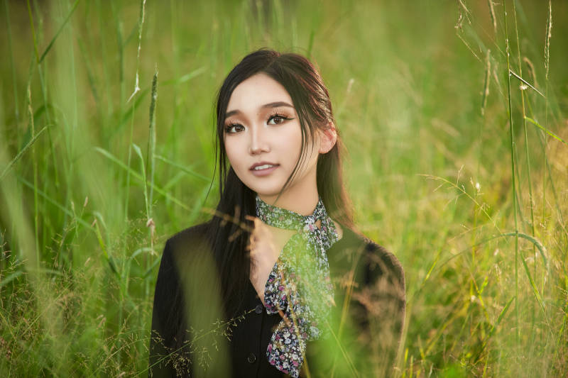 盛夏夕阳照射下花丛草地中的亚洲美女图片