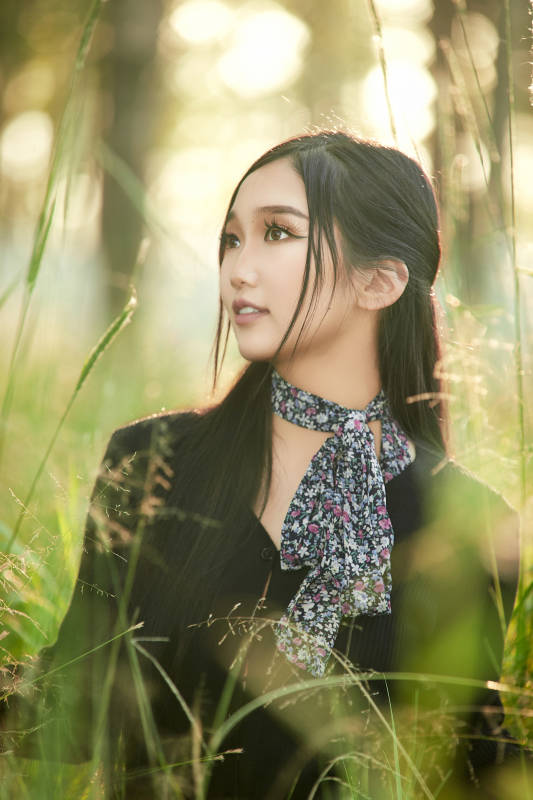 盛夏夕阳照射下花丛草地中的亚洲美女图片