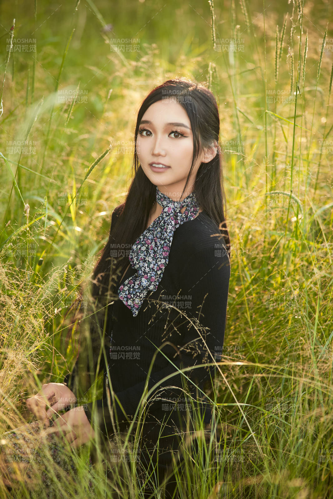 盛夏夕阳照射下花丛草地中的亚洲美女图片