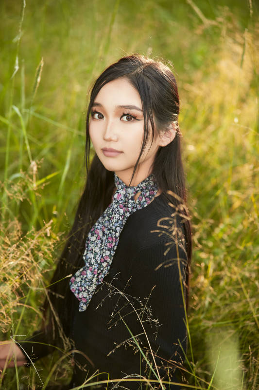 盛夏夕阳照射下花丛草地中的亚洲美女图片