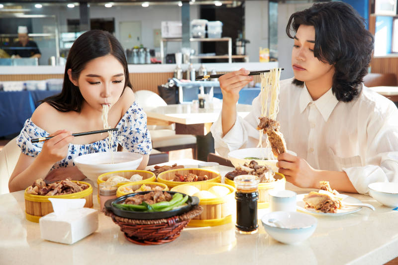 在茶餐厅大吃特吃的东方情侣图片