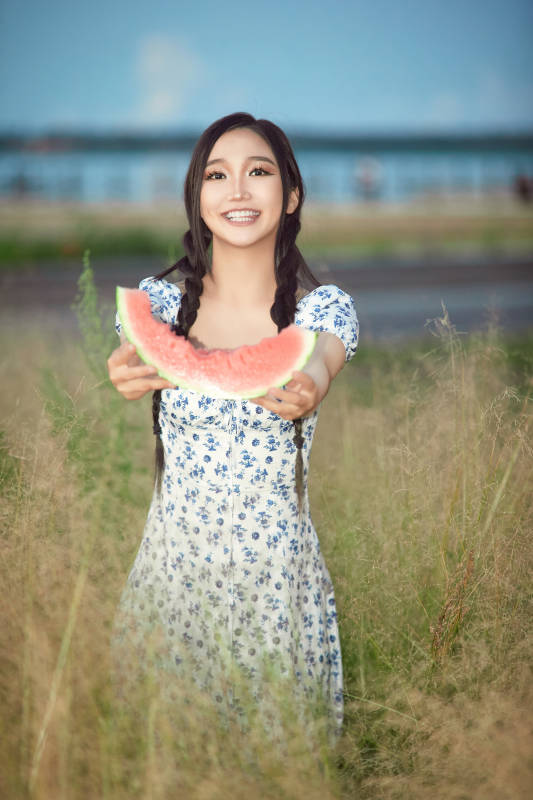 夏天在公园湖边开心吃西瓜的美女图片