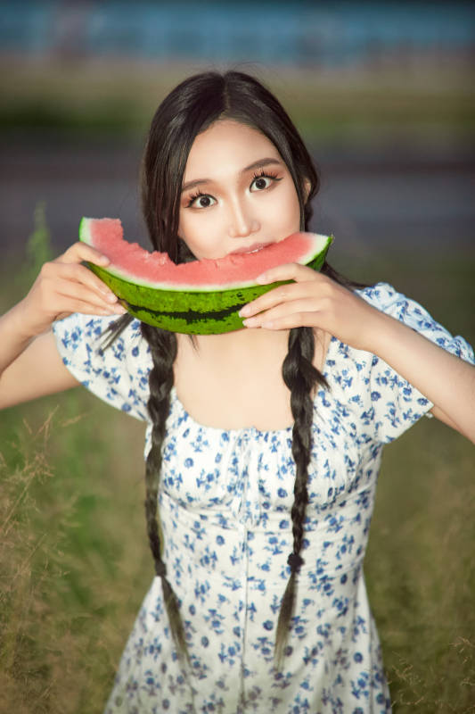 夏天在公园湖边开心吃西瓜的美女图片