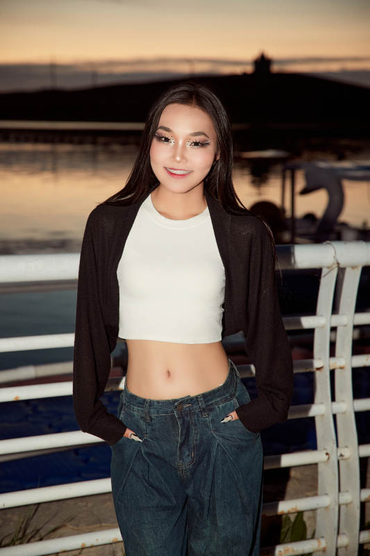 傍晚在湖边欣赏风景拍照的亚洲美女图片