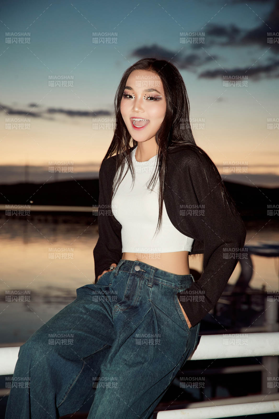 傍晚在湖边欣赏风景拍照的亚洲美女图片