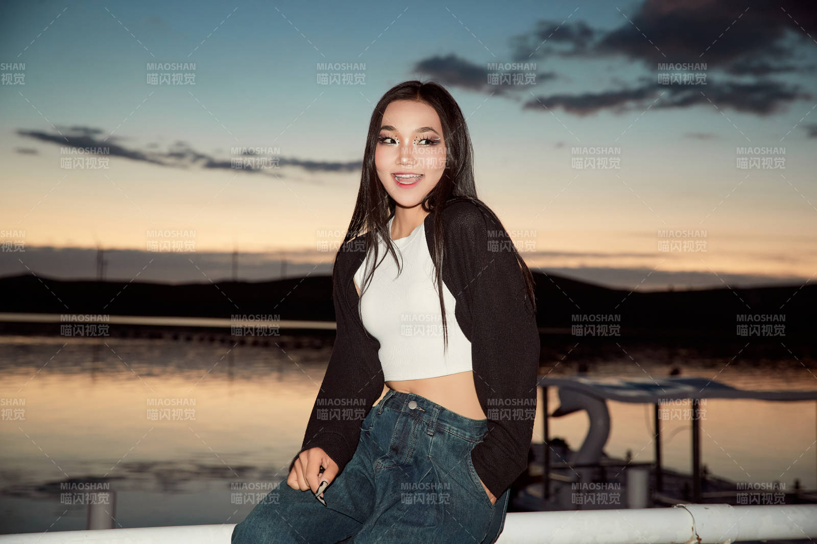 傍晚在湖边欣赏风景拍照的亚洲美女图片