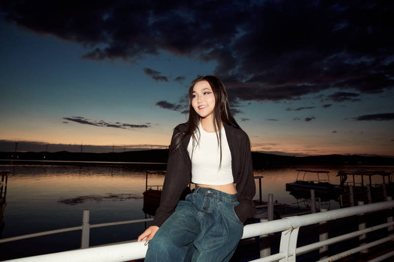 傍晚在湖边欣赏风景拍照的亚洲美女图片