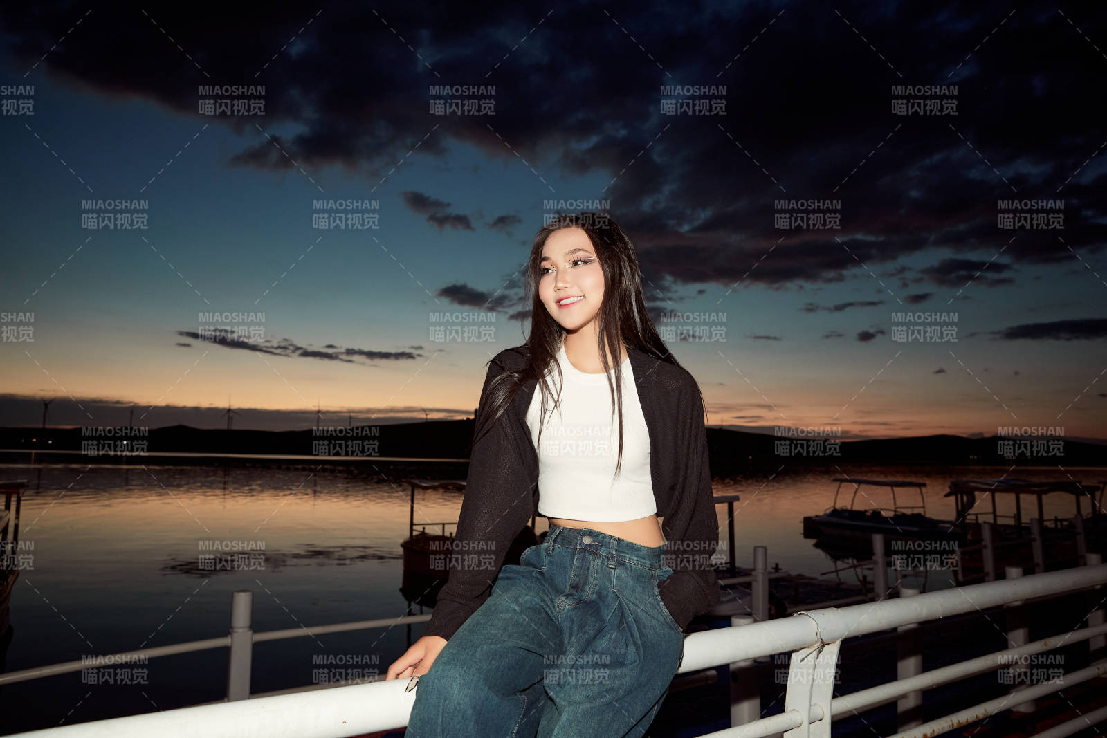 傍晚在湖边欣赏风景拍照的亚洲美女图片