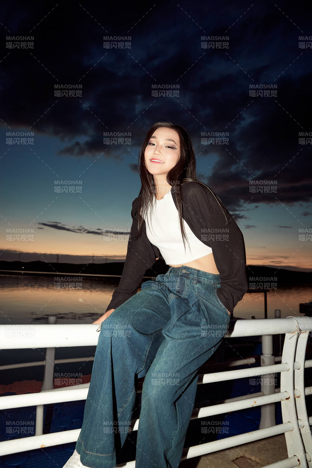 傍晚在湖边欣赏风景拍照的亚洲美女图片