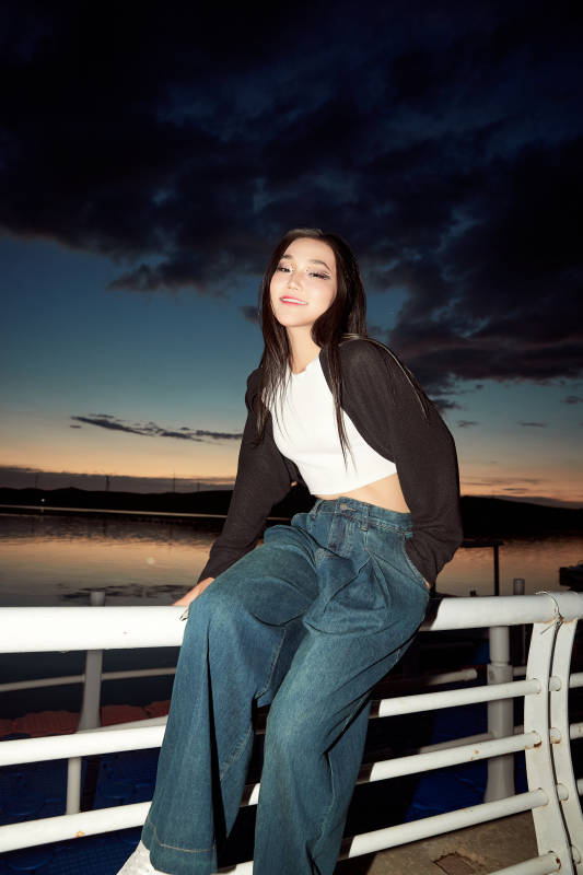 傍晚在湖边欣赏风景拍照的亚洲美女图片