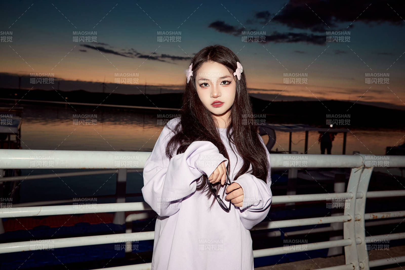 傍晚在湖边欣赏风景拍照的亚洲美女图片