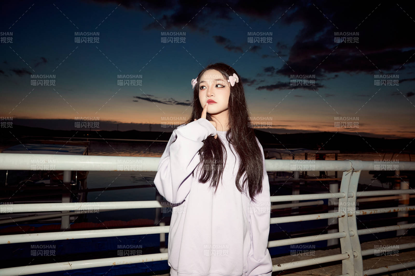 傍晚在湖边欣赏风景拍照的亚洲美女图片
