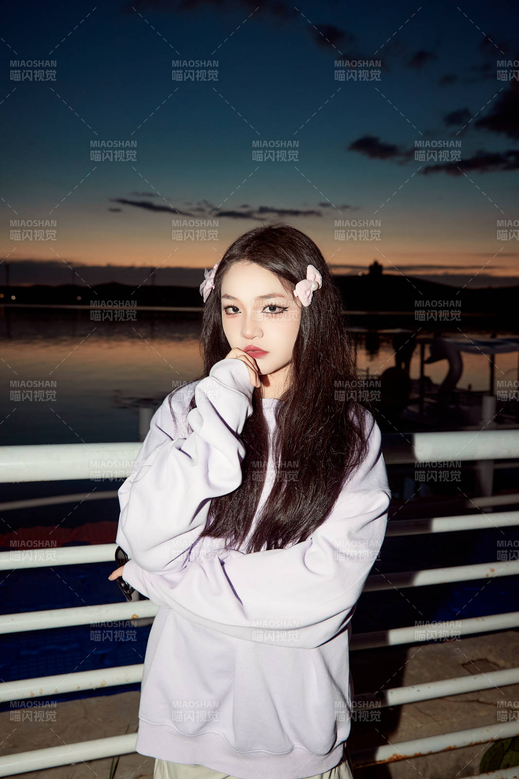 傍晚在湖边欣赏风景拍照的亚洲美女图片