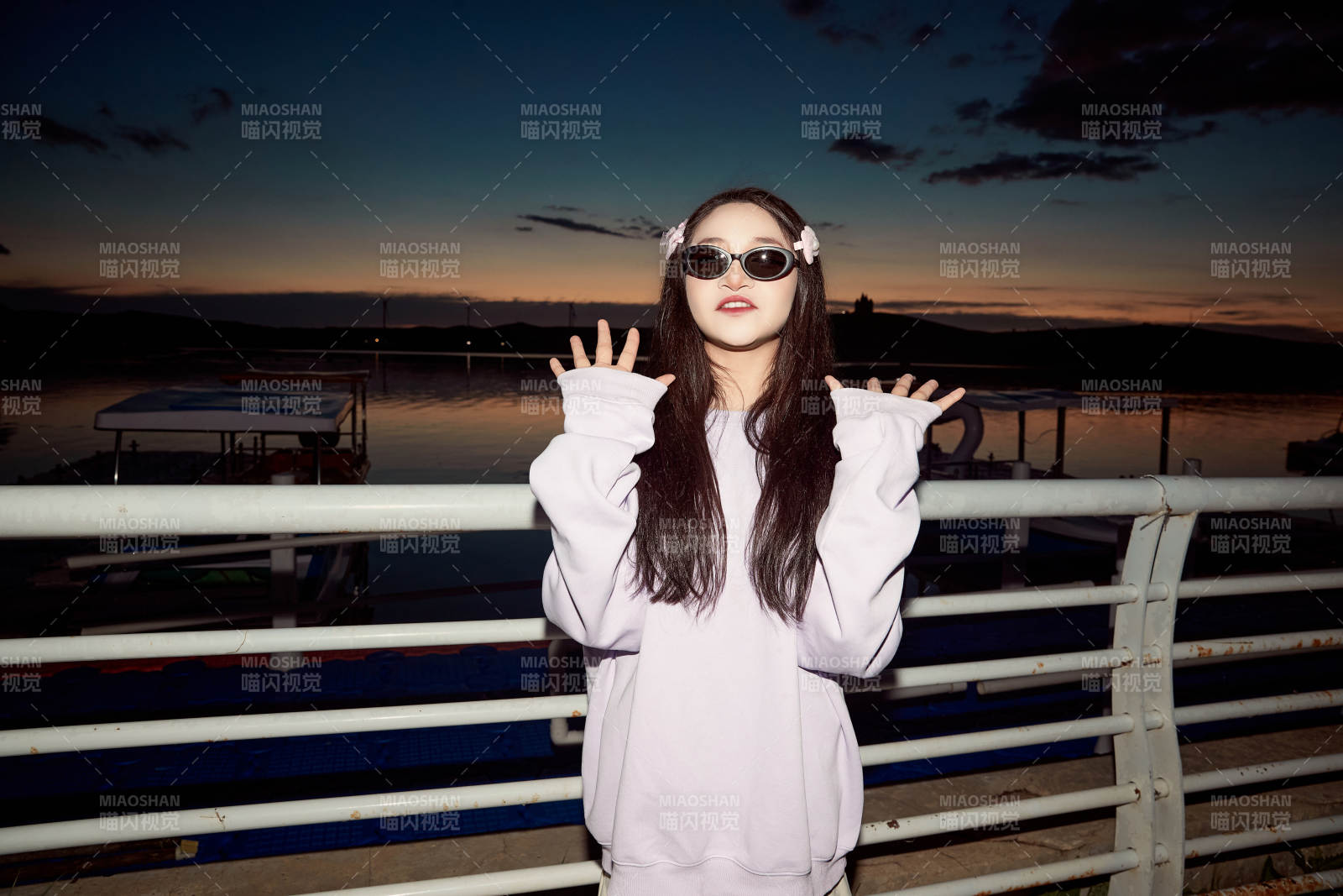 傍晚在湖边欣赏风景拍照的亚洲美女图片