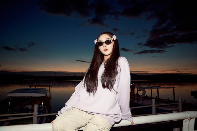 傍晚在湖边欣赏风景拍照的亚洲美女图片