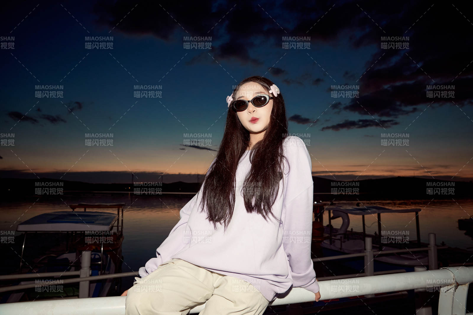 傍晚在湖边欣赏风景拍照的亚洲美女图片