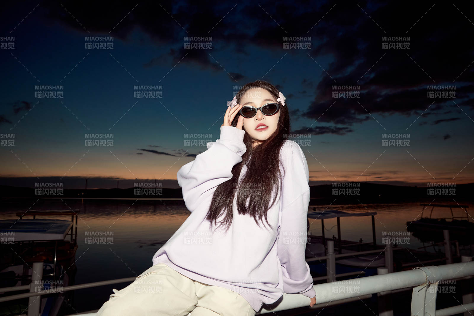 傍晚在湖边欣赏风景拍照的亚洲美女图片