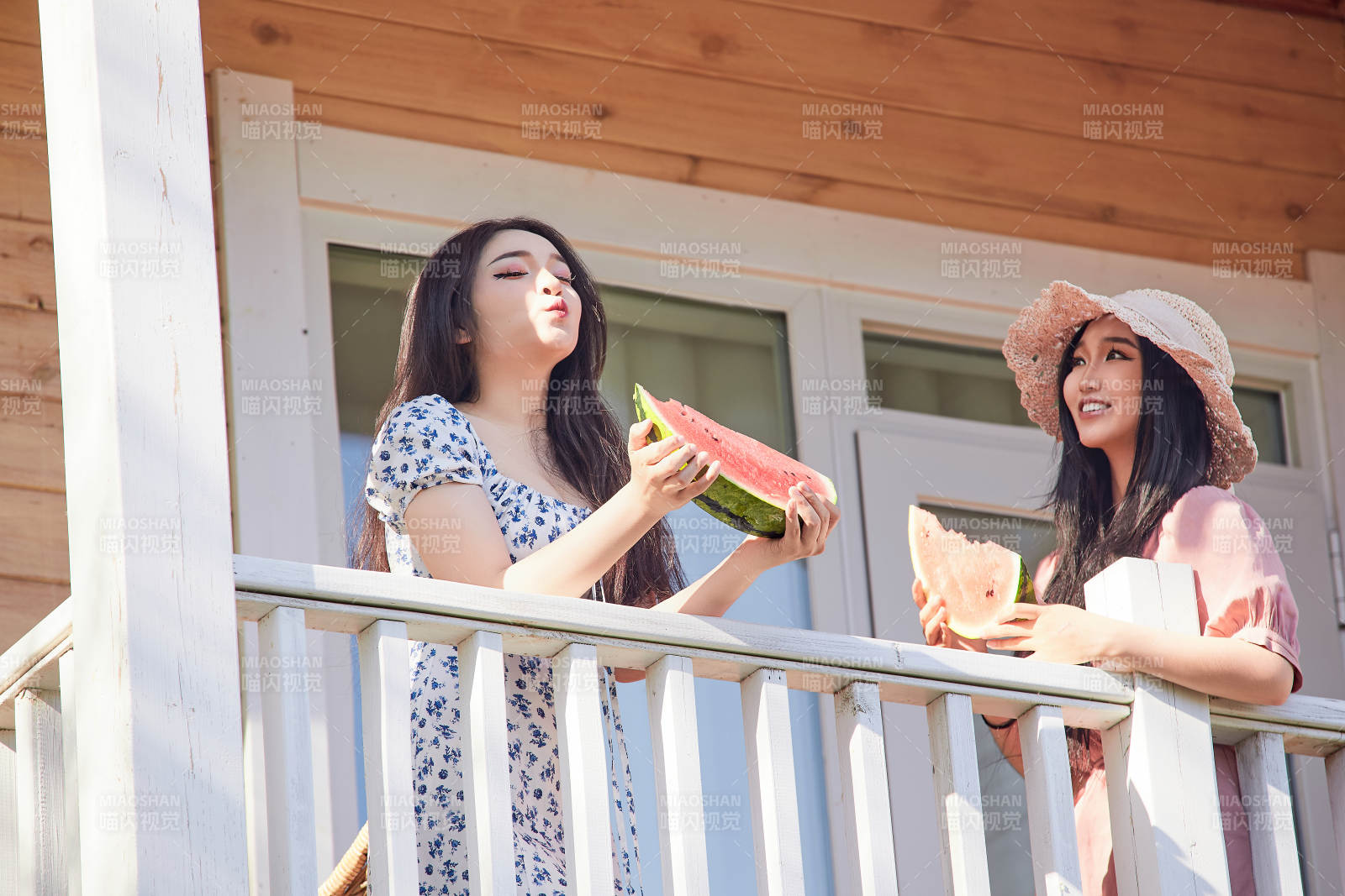 夏天在木质别墅门廊外吃西瓜的美女图片