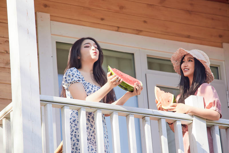 夏天在木质别墅门廊外吃西瓜的美女图片