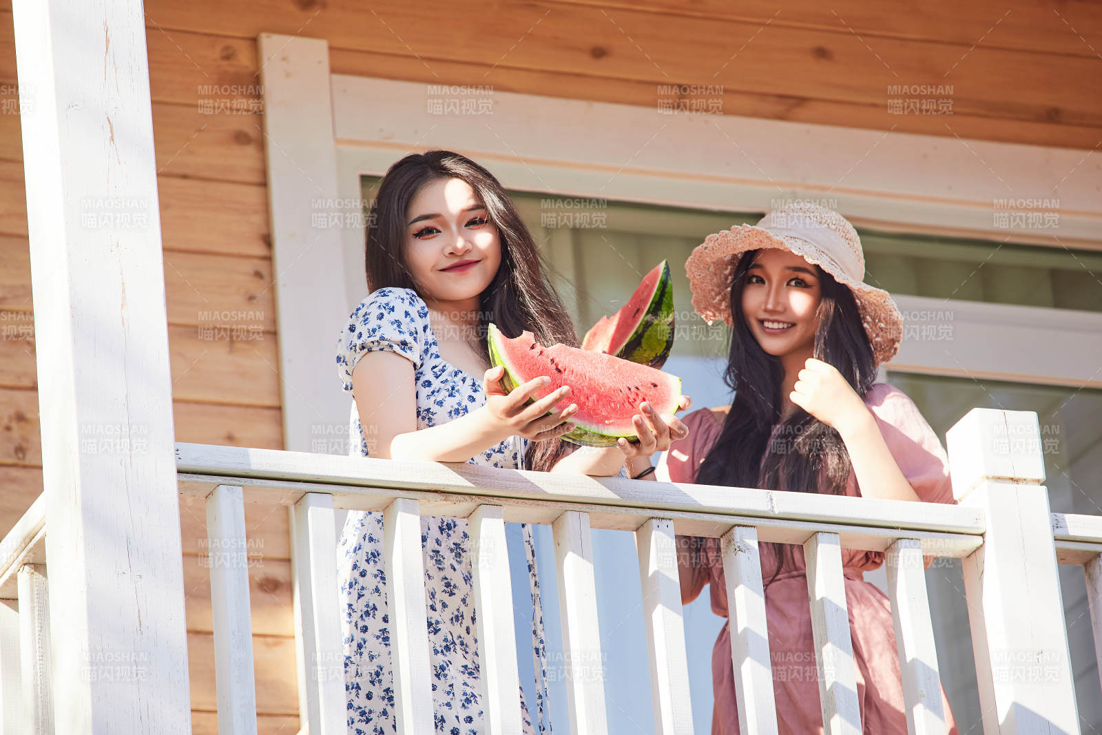 夏天在木质别墅门廊外吃西瓜的美女图片