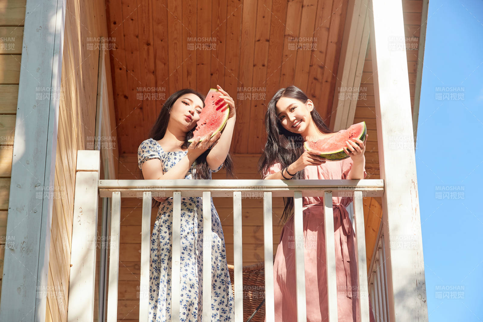 夏天在木质别墅门廊外吃西瓜的美女图片