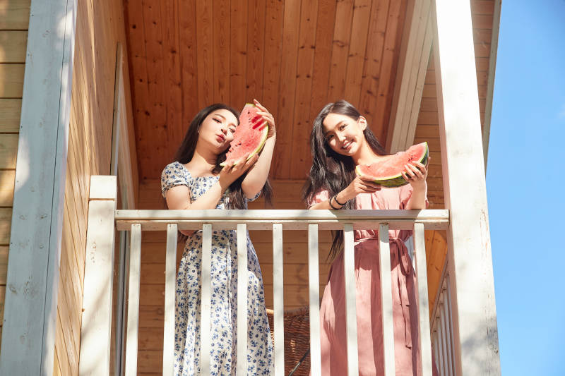 夏天在木质别墅门廊外吃西瓜的美女图片