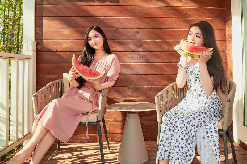 夏天在木质别墅门廊外吃西瓜的美女图片