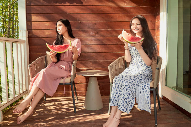 夏天在木质别墅门廊外吃西瓜的美女图片