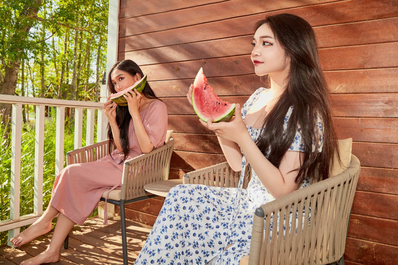 夏天在木质别墅门廊外吃西瓜的美女图片