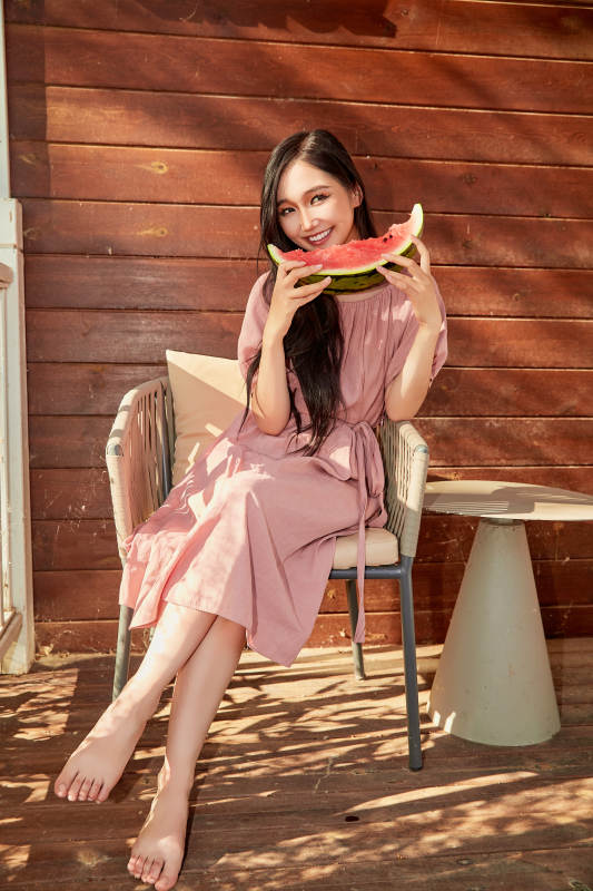 夏天在木质别墅门廊外吃西瓜的美女图片