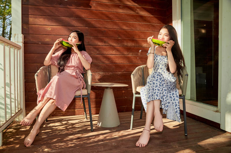 夏天在木质别墅门廊外吃西瓜的美女图片