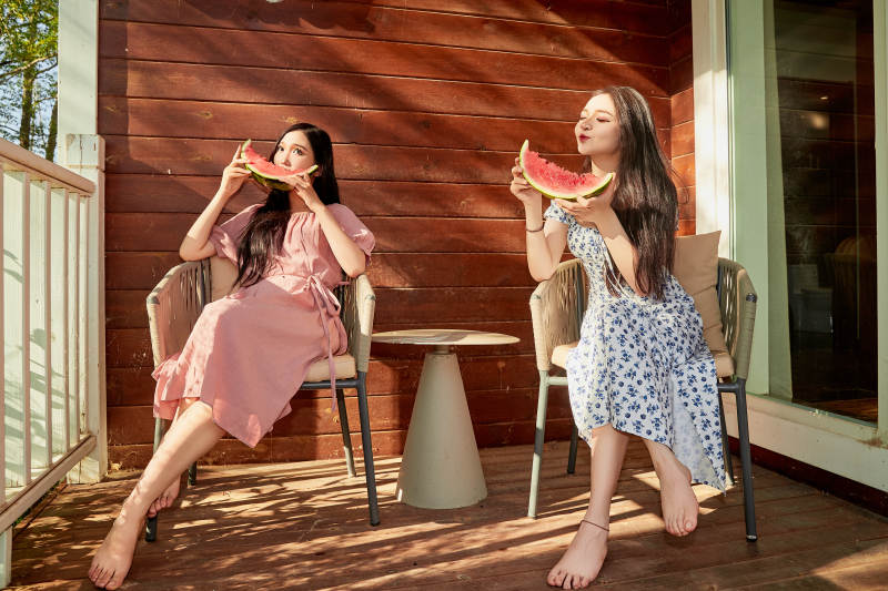 夏天在木质别墅门廊外吃西瓜的美女图片