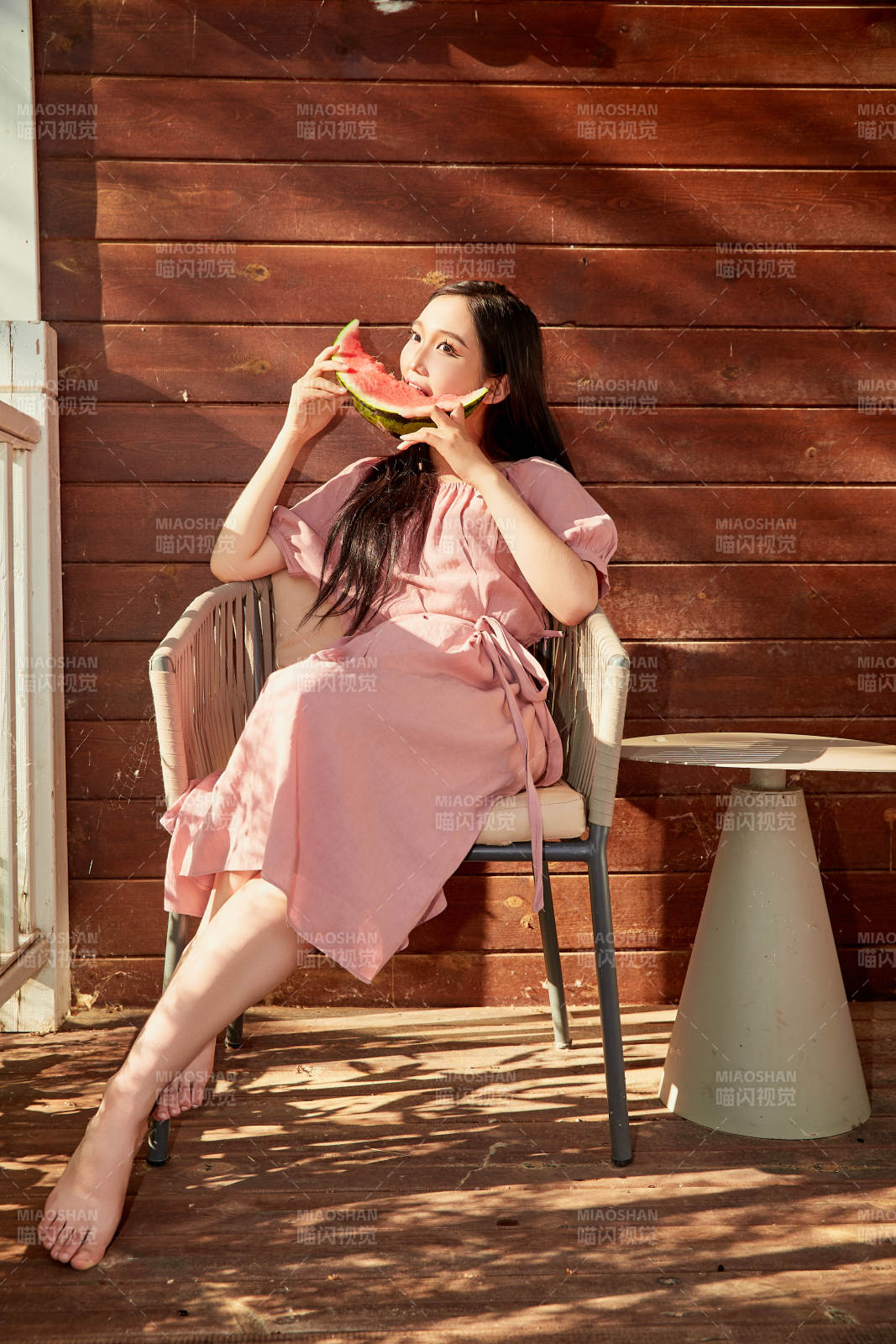 夏天在木质别墅门廊外吃西瓜的美女图片