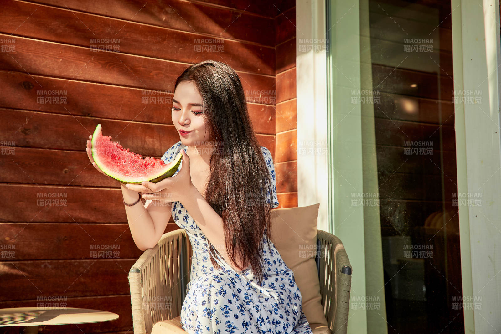 夏天在木质别墅门廊外吃西瓜的美女图片