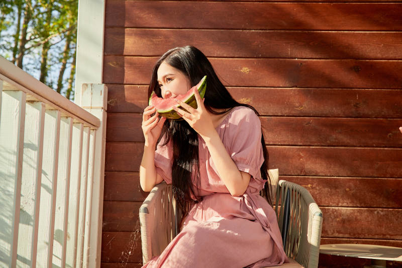 夏天在木质别墅门廊外吃西瓜的美女图片